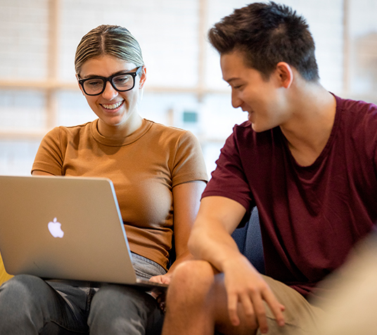 Two friends looking at a laptop